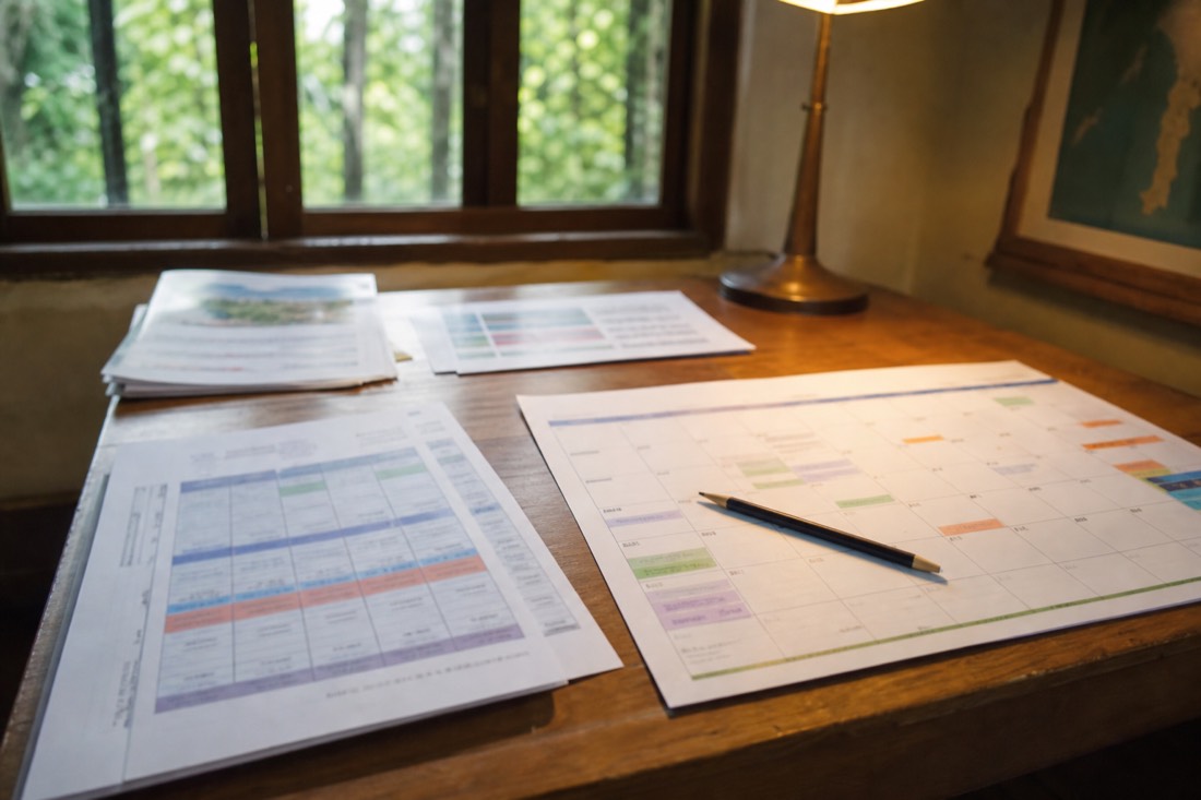 Printed retreat schedules and a calendar spread on a desk with a pencil