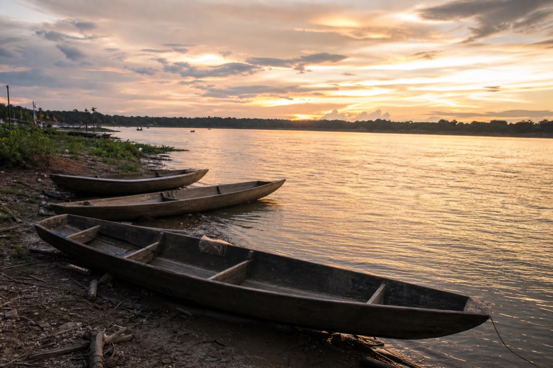 Ucayali river shoreline at Yarinacocha with wooden boats pulled up on the bank at dusk