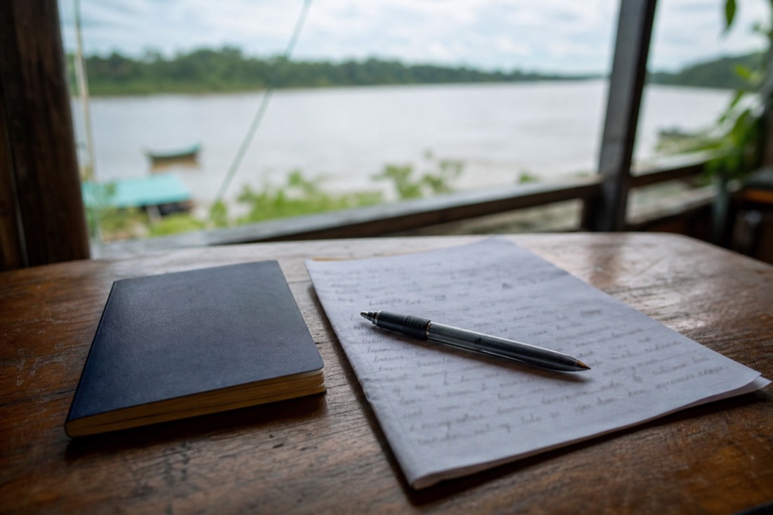 Close-up of a pen resting on a sheet of handwritten questions beside an open passport on a rustic table, handwriting blurred and unreadable, Iquitos region