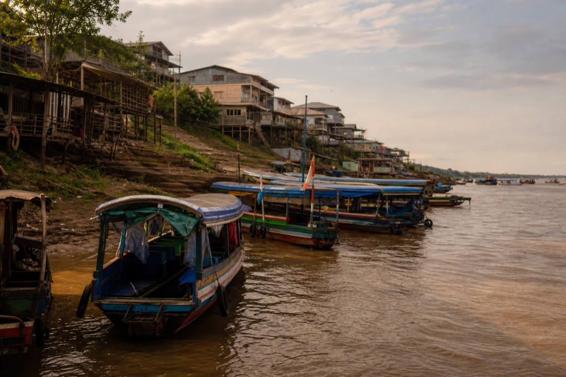 Small wooden boats moored along the Itaya riverfront at Iquitos in late afternoon light