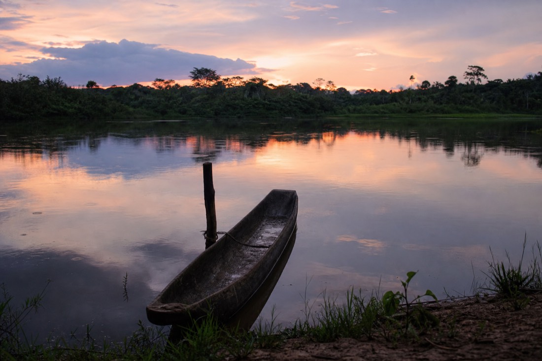 Dugout canoe on the still water of Yarinacocha lake near Pucallpa at dusk, heartland of the Shipibo ayahuasca lineages
